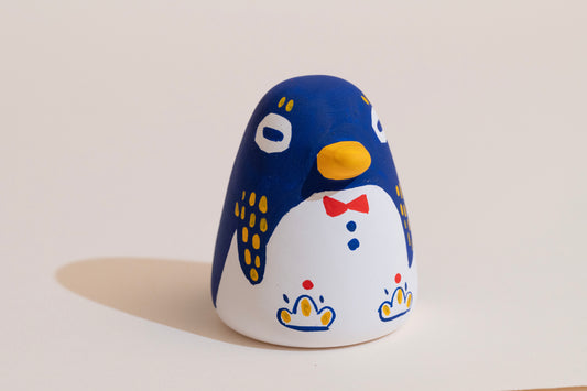 Ceramic penguin figurine with a bow tie on a light background