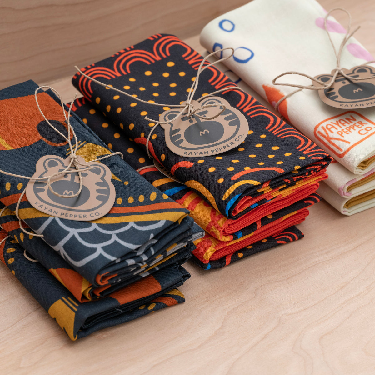 Folded bandanas packaged with jute string and tiger logo tags